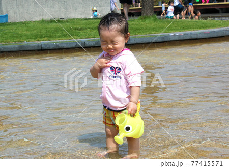 水遊びで顔が濡れて嫌な顔をする子ども 水遊びで顔が濡れて嫌な顔をする子ども 77415571