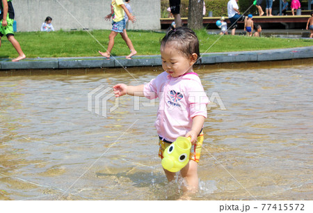 水遊び中に水しぶきがかかる子ども 水遊び中に水しぶきがかかる子ども 77415572