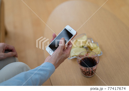 自粛生活中お家でスマホを使うシニア女性 自粛生活中お家でスマホを使うシニア女性 77417674