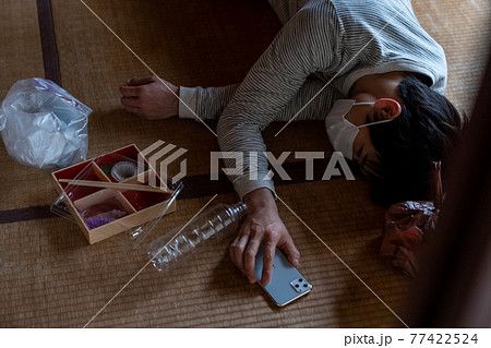 電話を握りしめたまま倒れる具合が悪い若者 電話を握りしめたまま倒れる具合が悪い若者 77422524