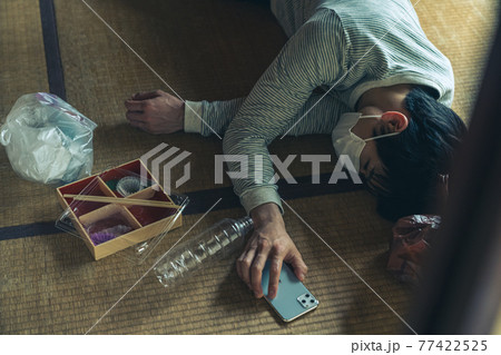 電話を握りしめたまま倒れる具合が悪い若者 電話を握りしめたまま倒れる具合が悪い若者 77422525