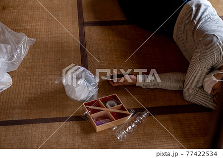 電話を握りしめたまま倒れる具合が悪い若者 77422534