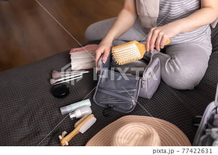 Smiling woman writing list of necessary cosmetics getting ready trip vacation storage organization 77422631