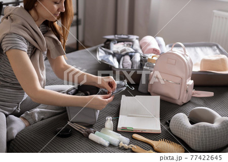 Smiling woman writing list of necessary cosmetics getting ready trip vacation storage organization Smiling woman writing list of necessary cosmetics getting ready trip vacation storage organization 77422645