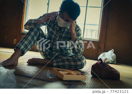 電話する具合が悪い若者 77423121