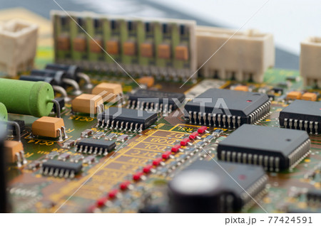 Close-up of electronic circuit board PCB with microchip, integrated circuits, resistances and electronic connections. 77424591
