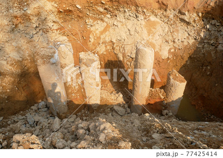 SEREMBAN, MALAYSIA -MARCH 05, 2021:  Construction workers cutting concrete bore pile up to the determined level at the construction site. Stage fo work before fabricating the pile cap.   77425414
