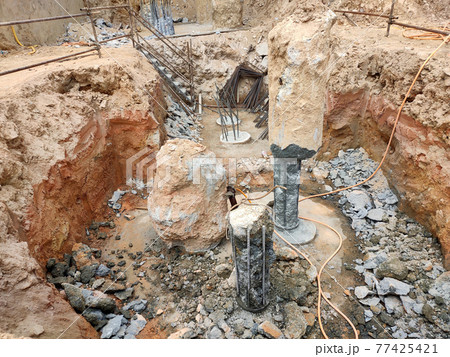 SEREMBAN, MALAYSIA -MARCH 05, 2021:  Construction workers cutting concrete bore pile up to the determined level at the construction site. Stage fo work before fabricating the pile cap.   77425421