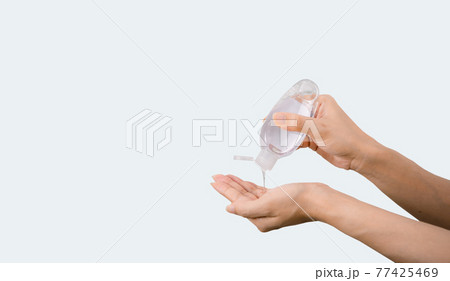 Alcohol hand sanitizer on a woman's hand 77425469