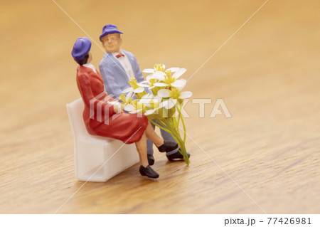 白い花束とベンチに座るカップル 77426981