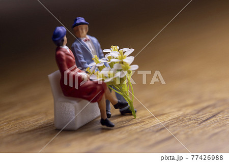 白い花束とベンチに座るカップル 77426988