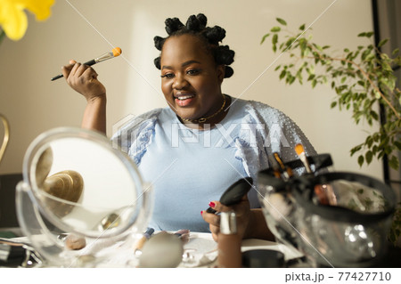 Woman preparing makeup and smiling at camera while shooting the video tutorial Woman preparing makeup and smiling at camera while shooting the video tutorial 77427710