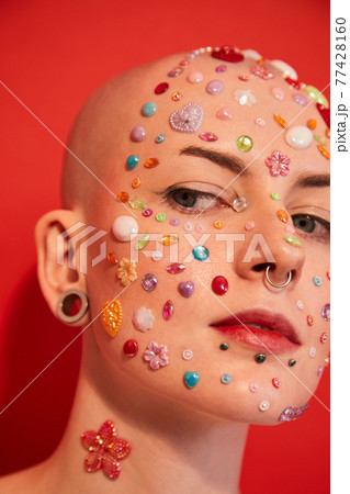 Masculine woman with rhinestones at her face and ear tunnels Masculine woman with rhinestones at her face and ear tunnels 77428160