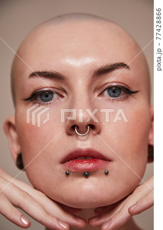 Masculine woman having nude makeup and naked shoulders standing in front of the camera 77428866