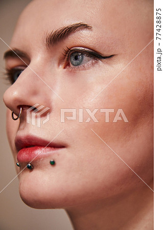 Short haired woman looking straight and posing with serious face 77428875