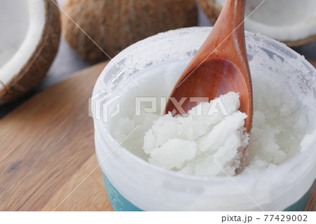 spoon with coconut oil and nut on black background spoon with coconut oil and nut on black background 77429002