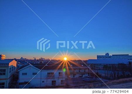 住宅街の奥から登ってくる日の出 77429404