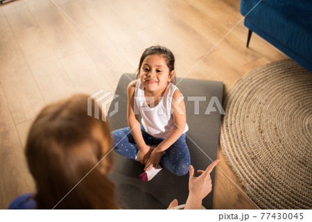 Girl sitting at home at the floor in lotus position, while meditating 77430045