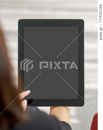 Businesswoman in black suit use her finger press on the screen to waking tablet computer from sleep mode. Businesswoman in black suit use her finger press on the screen to waking tablet computer from sleep mode. 77430198