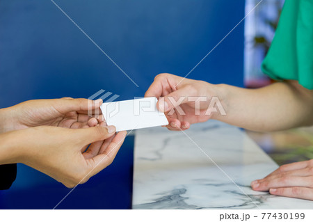 Close up woman hands reciving white plastic card. 77430199
