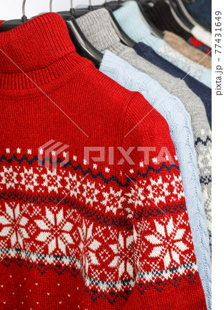 Collection of knitted sweaters on hanger rack in a store or at a wardrobe Collection of knitted sweaters on hanger rack in a store or at a wardrobe 77431649