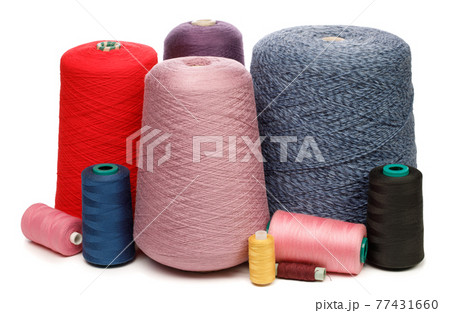 Cones and spools of color threads on white background Cones and spools of color threads on white background 77431660