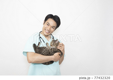 猫を抱く男性獣医師 猫を抱く男性獣医師 77432320