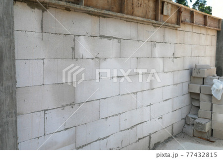 SEREMBAN, MALAYSIA -MARCH 19, 2021: Autoclaved aerated concrete block or known as AAC block used at the construction site. Install by workers using special mortar. Easy and fast.   77432815