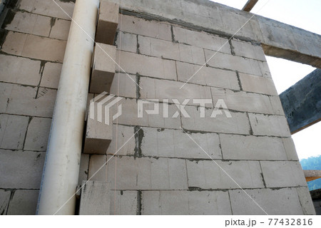 SEREMBAN, MALAYSIA -MARCH 19, 2021: Autoclaved aerated concrete block or known as AAC block used at the construction site. Install by workers using special mortar. Easy and fast.   77432816