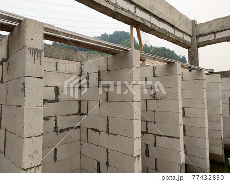 SEREMBAN, MALAYSIA -MARCH 19, 2021: Autoclaved aerated concrete block or known as AAC block used at the construction site. Install by workers using special mortar. Easy and fast. SEREMBAN, MALAYSIA -MARCH 19, 2021: Autoclaved aerated concrete block or known as AAC block used at the construction site. Install by workers using special mortar. Easy and fast. 77432830