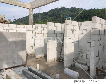 SEREMBAN, MALAYSIA -MARCH 19, 2021: Autoclaved aerated concrete block or known as AAC block used at the construction site. Install by workers using special mortar. Easy and fast.   77432836