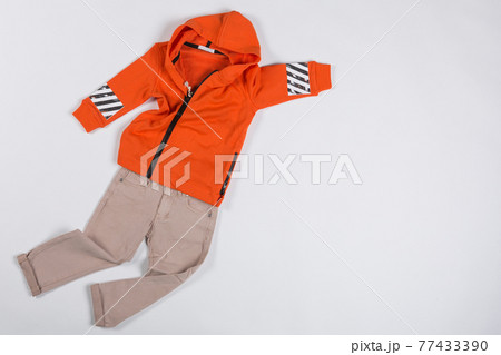 children's clothing, beige pants and orange jacket are laid out like a rapidly flying superhero, the concept of children's clothing, copy space children's clothing, beige pants and orange jacket are laid out like a rapidly flying superhero, the concept of children's clothing, copy space 77433390