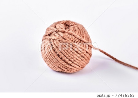 Ball of brown yarn, white background. Ball of brown yarn, white background. 77436565