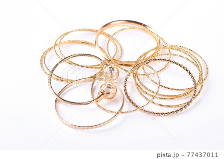Golden bracelets and jewelry, white background. 77437011