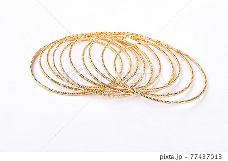 Golden bracelets on white background. 77437013