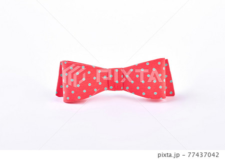 Red dotted bow tie on white background. 77437042