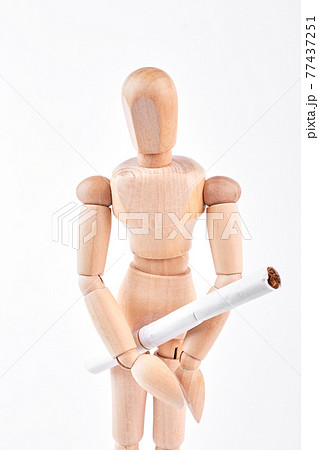 Wooden dummy with white cigarette. Wooden dummy with white cigarette. 77437251