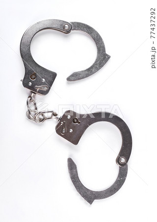 Silver handcuffs on white background. 77437292