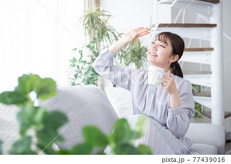 リビング　くつろぐ　若い女性　リラクス 77439016