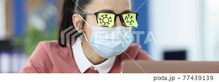 Viruses are drawn on glasses of young business woman with black marker Viruses are drawn on glasses of young business woman with black marker 77439139