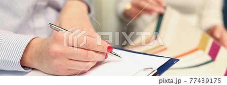 Designer writing with ballpoint pen in documents in curtain workshop Designer writing with ballpoint pen in documents in curtain workshop 77439175