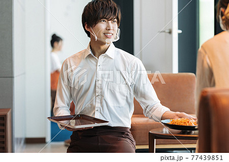 マウスシールドをつけた飲食店スタッフの仕事風景 77439851