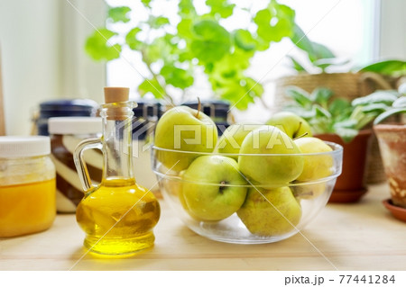 Home pantry, plants in pots, honey, chocolate paste, apples, bottle of olive oil 77441284
