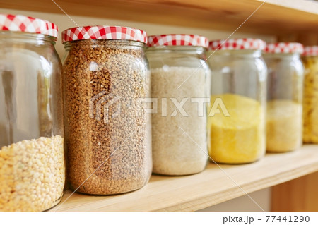 Kitchen pantry, wooden shelves with jars and containers with food, food storage. Kitchen pantry, wooden shelves with jars and containers with food, food storage. 77441290