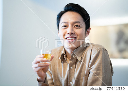 ウイスキーをストレートで飲む男性 77441530