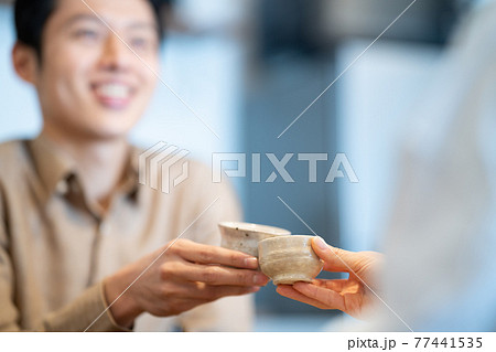 日本酒で乾杯するカップル 77441535