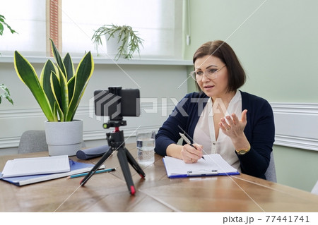 Mature confident woman counselor recording video stream, online consultation Mature confident woman counselor recording video stream, online consultation 77441741