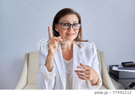 Mature businesswoman looking talking to webcam, business and education online Mature businesswoman looking talking to webcam, business and education online 77442212