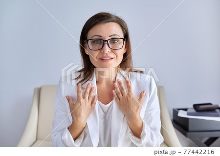 Mature businesswoman looking talking to webcam, business and education online Mature businesswoman looking talking to webcam, business and education online 77442216