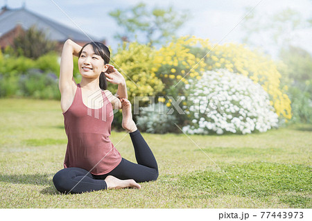 緑あふれる公園でヨガをする若い女性 緑あふれる公園でヨガをする若い女性 77443973